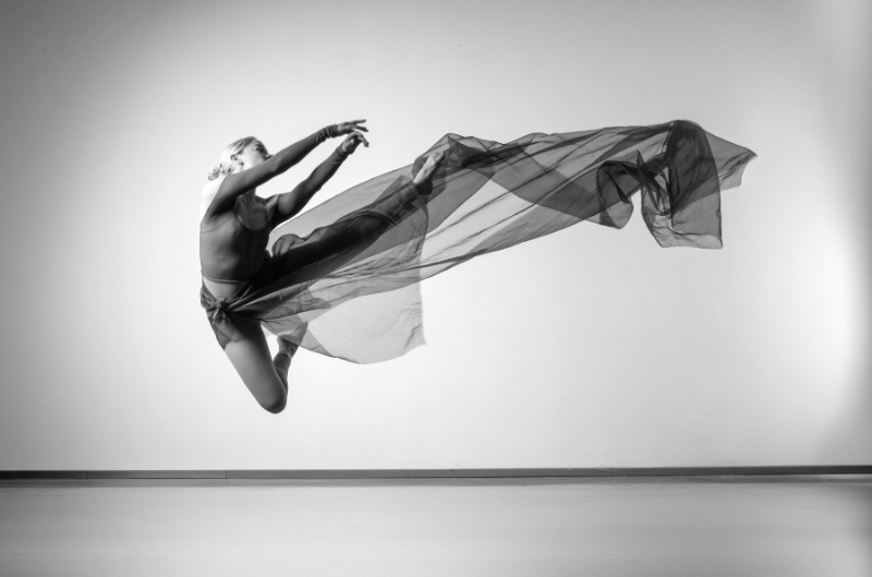 Bailarina saltando con tela en movimiento para presentar las actividades y talleres de Un Lugar