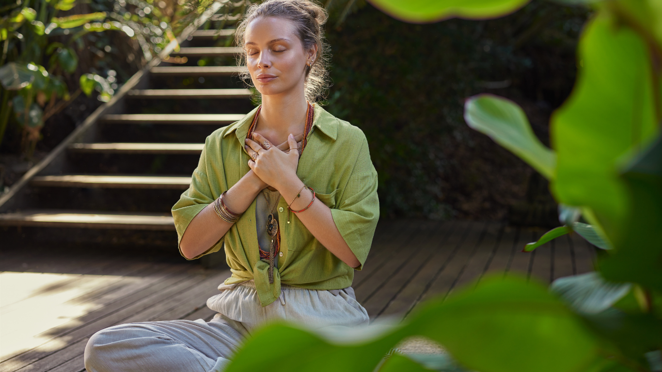 Mujer practicando respiración consciente en un entorno natural dentro del programa Salud y Bienestar