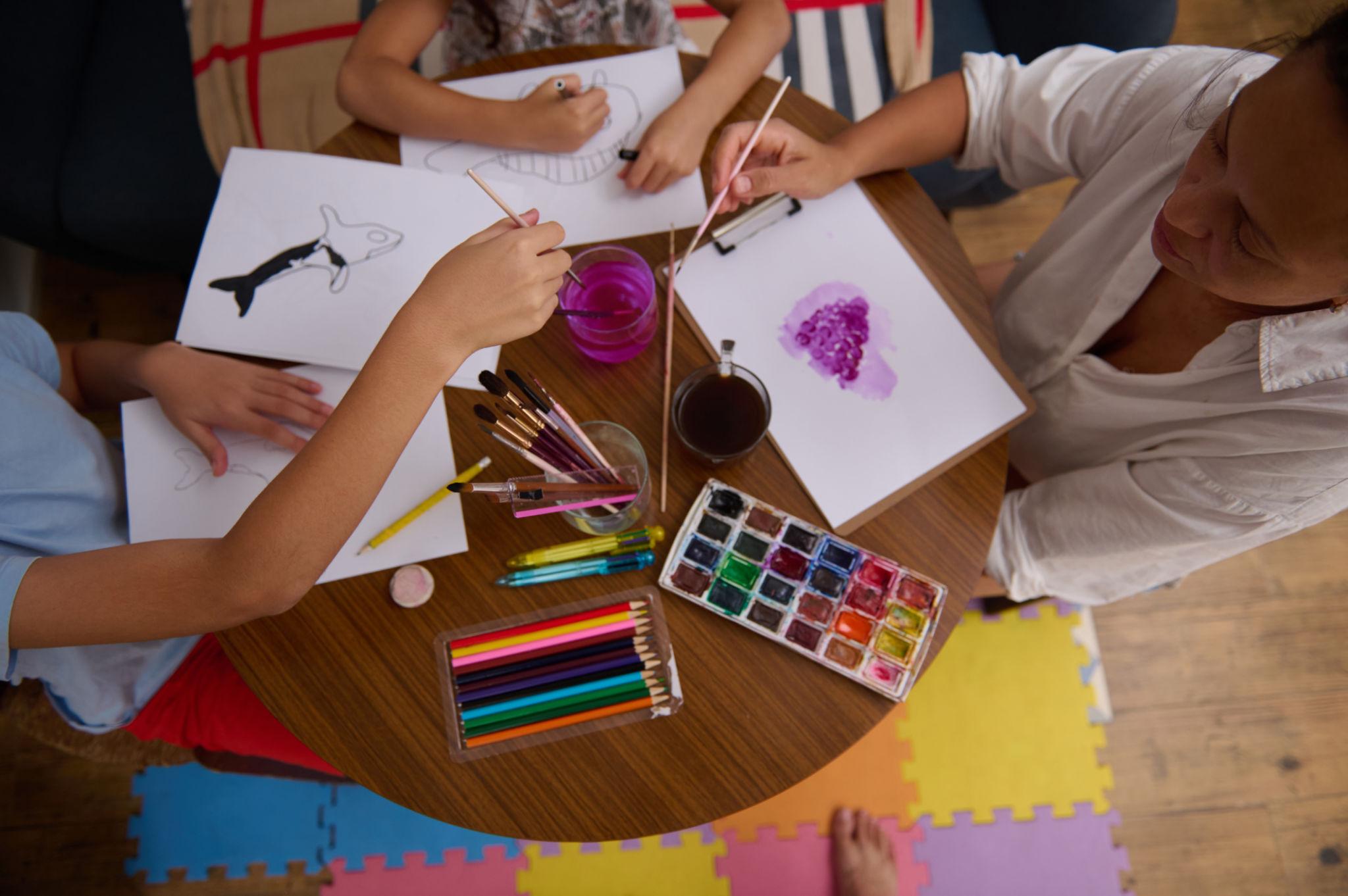 Niña pintando en el suelo durante una experiencia artística infantil