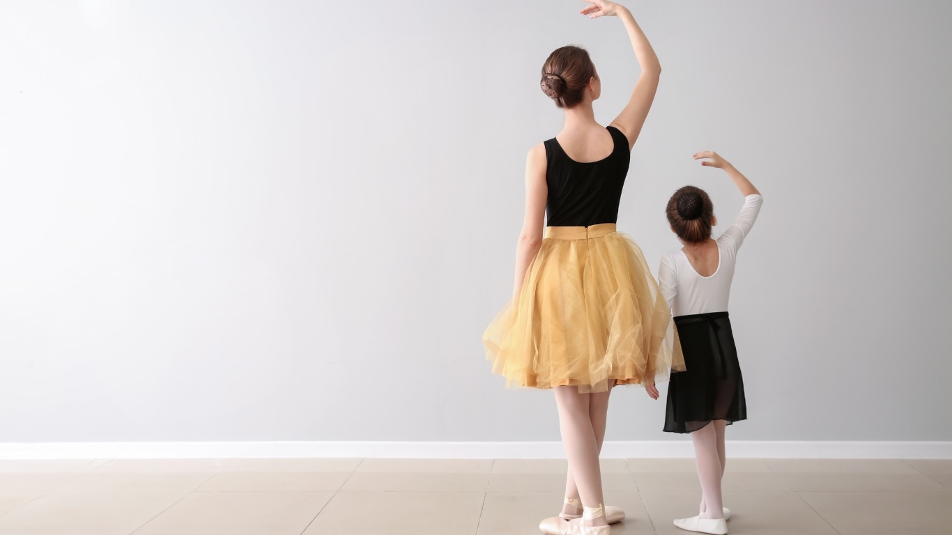 Profesora y alumna practicando posiciones de danza